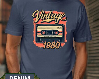 May include: Denim blue t-shirt with a vintage design. The graphic features the word "Vintage" above a cassette tape illustration, with "1980" below. The cassette tape has the words "Limited Edition" and "Original Playlist".