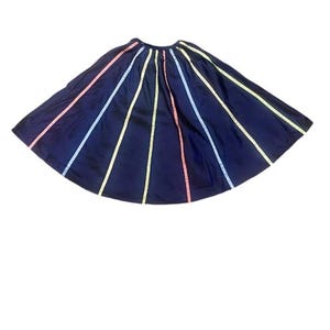 May include: A navy blue skirt with colorful stripes. The skirt is pleated and has a flared silhouette.