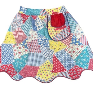 May include: A colorful patchwork skirt with a scalloped hem. The skirt features a variety of patterned fabrics in red, blue, yellow, and white. A red pocket is sewn on the front. The skirt is a vintage style.