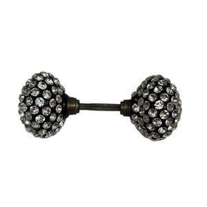 May include: Two black door knobs with a silver metal connecting rod. Each knob is covered in small, clear rhinestones.