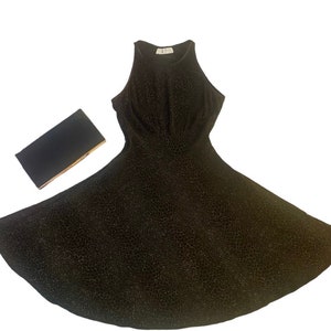 May include: A black sparkly sleeveless dress with a scoop neck and a flared skirt.