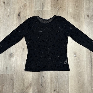 May include: Black long-sleeved sheer top with a floral pattern.