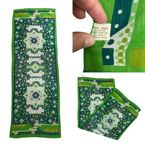 May include: A green and white rayon scarf with a geometric pattern. The scarf is hand-printed and has a label that reads "Ripple Sheer All Rayon Hand Printed RN. 24409 Made in Japan".