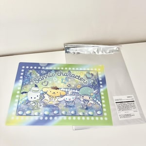 May include: A clear plastic folder featuring Sanrio characters. The folder has a blue, green, and yellow border with the words "Sanrio characters" in the center. The characters are in the center of the folder. A clear plastic bag is next to the folder.
