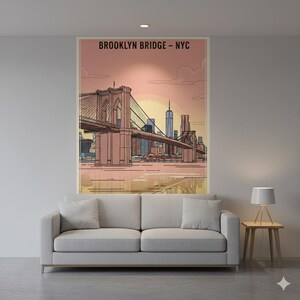 May include: A framed art print featuring the Brooklyn Bridge in New York City. The artwork depicts the bridge with a pink and orange sunset backdrop, with the text "BROOKLYN BRIDGE - NYC" at the top. The print is displayed above a gray sofa.
