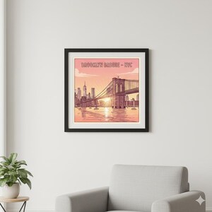 May include: Framed art print featuring a line drawing of the Brooklyn Bridge in New York City. The artwork is in shades of pink, orange, and brown, with the text "BROOKLYN BRIDGE - NYC" at the top. The image is set against a sunset backdrop.