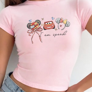 A pink t-shirt with a graphic design featuring cartoon characters and the text "I am speed".