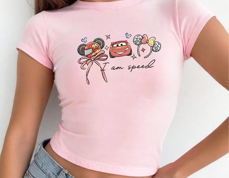 A pink t-shirt with a graphic design featuring cartoon characters and the text "I am speed".