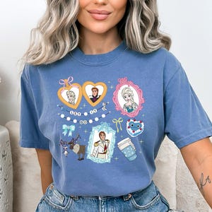 A woman wearing a blue t-shirt with various cartoon characters and designs printed on it.