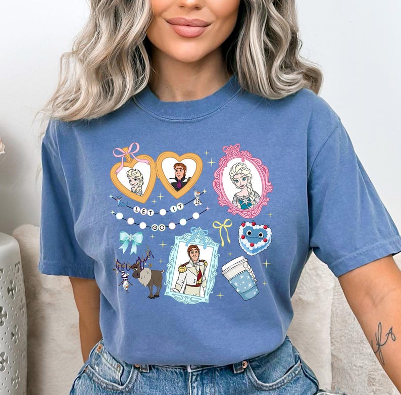 A woman wearing a blue t-shirt with various cartoon characters and designs printed on it.