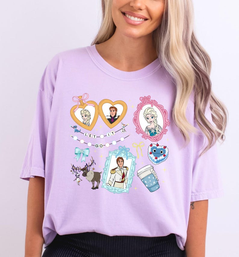 A woman wearing a pink t-shirt with various cartoon characters and illustrations, including Elsa from Frozen, a heart, a cup, and other whimsical elements.