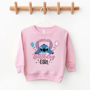 a pink sweatshirt hanging on a clothes line