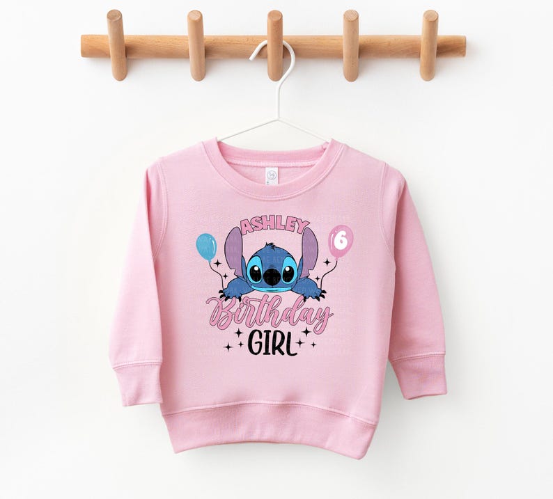 a pink sweatshirt hanging on a clothes line