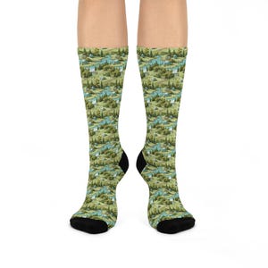 May include: Socks with a landscape pattern featuring rivers, trees, and buildings in green, blue, and brown. The heels and toes are black. The socks are patterned with a repeating design.