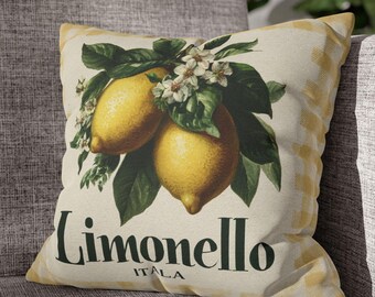 May include: Square throw pillow with a lemon design. The pillow features two yellow lemons with green leaves and white flowers. The text "Limonello ITALIA" is printed below the lemons. The pillow has a yellow and white gingham border.