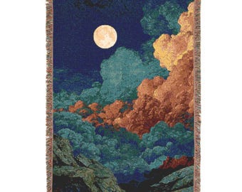 Peut inclure: Couverture tissée représentant une scène de ciel nocturne avec une pleine lune, des nuages dans les tons de bleu sarcelle, orange et jaune, et un fond bleu foncé. La couverture a une bordure à franges et une forme rectangulaire.