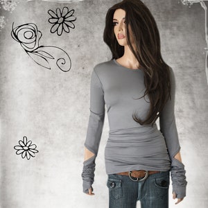 May include: A gray long-sleeved shirt with a fitted silhouette and thumbholes at the cuffs. The shirt has a round neckline and is made of a soft, stretchy fabric.