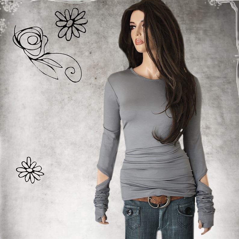May include: A gray long-sleeved shirt with a fitted silhouette and thumbholes at the cuffs. The shirt has a round neckline and is made of a soft, stretchy fabric.