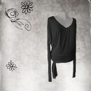 May include: A black long-sleeved shirt with a V-neck and a tie at the waist.