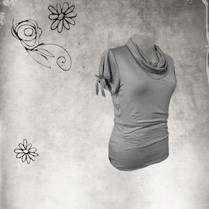 May include: A gray cowl neck top with short sleeves and a tie detail at the shoulders.