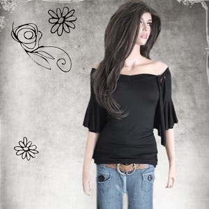 May include: A black off-the-shoulder top with bell sleeves and a tie detail at the neckline. The top is worn with blue jeans and a brown belt.