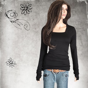 May include: A black long-sleeved shirt with a square neckline and thumbholes. The shirt is fitted and has a slightly cropped length. The model is wearing the shirt with blue jeans and a brown belt.