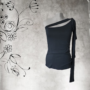 May include: A dark gray one-shoulder top with a long sleeve on one side and a short sleeve on the other. The top is made of a soft, stretchy fabric.