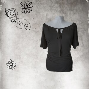 May include: A black, short-sleeved, off-the-shoulder top with a tie at the neckline.