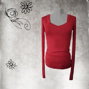 May include: A long-sleeved, red, fitted shirt with a V-neckline.
