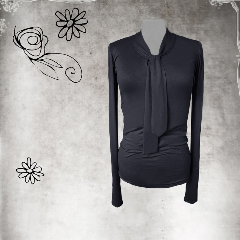 May include: A dark gray long-sleeved shirt with a tie at the neck.