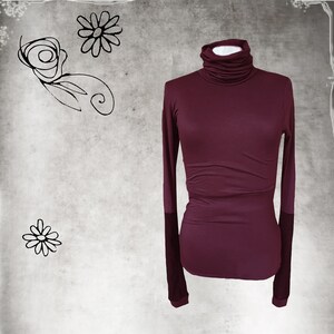 May include: A burgundy long-sleeved turtleneck shirt with a fitted silhouette.