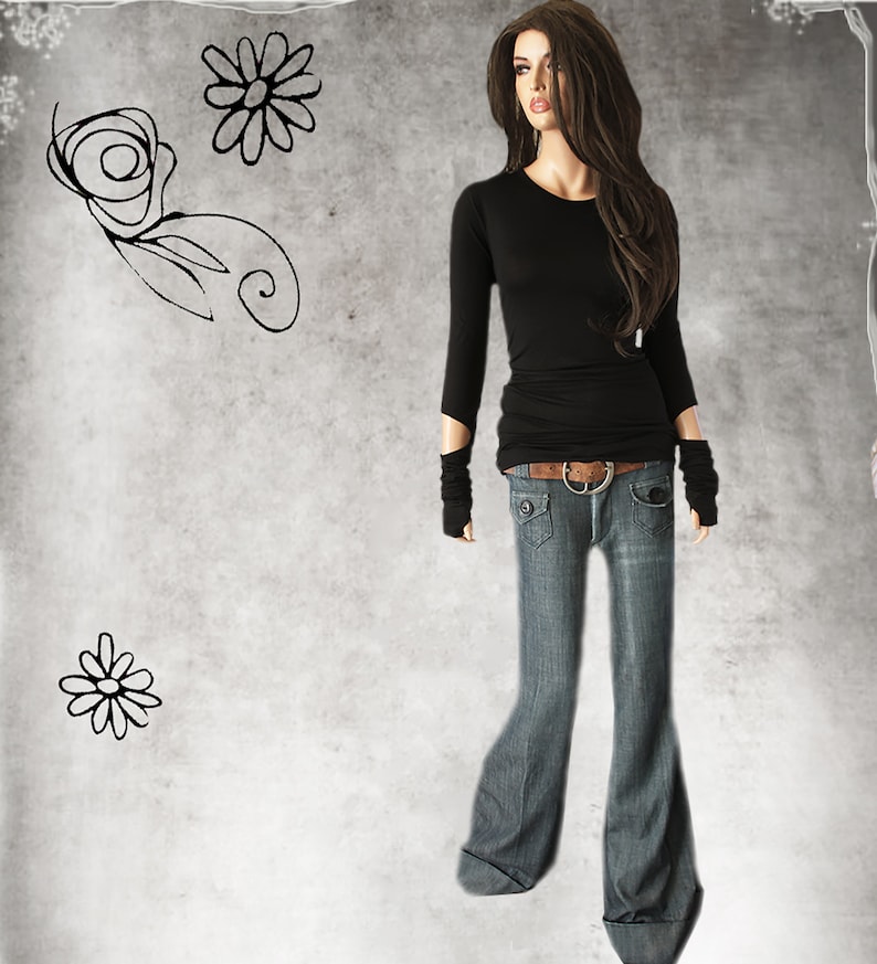 May include: A black long-sleeved shirt with a fitted silhouette and a brown belt. The shirt has long sleeves with a cuff detail. The model is wearing blue jeans with a wide leg.