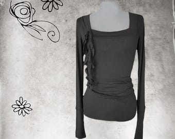 May include: A long-sleeved, dark gray shirt with a ruffled detail at the neckline.