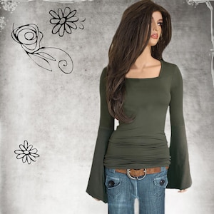 May include: An olive green long-sleeve top with a square neckline and flared sleeves. The top is paired with blue jeans and a brown belt. The mannequin is wearing a long brown wig. The background is a textured gray with floral doodles.