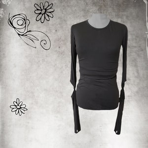 May include: A charcoal gray long-sleeved shirt with a round neckline and fitted silhouette. The sleeves have a unique detail with a small opening at the wrist.