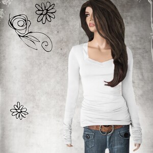 May include: White long-sleeved shirt with a scoop neck and cuffed sleeves. The shirt is tucked into blue jeans with a brown belt.