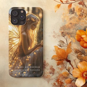 May include: A phone case featuring a fantasy illustration of a woman with blonde hair, wings, and a floral crown. The case has the text "UNTAMED AND LUMINOUS" in a serif font. The background is a warm, golden color.