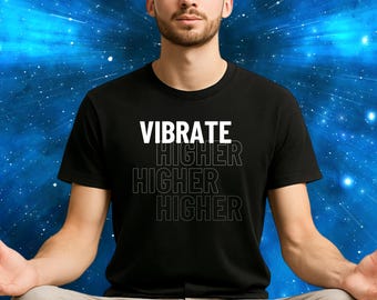 May include: Black t-shirt with the words "VIBRATE HIGHER HIGHER HIGHER" in white and outlined text. The person in the image is wearing the shirt and is sitting with their legs crossed and eyes closed. The background is a blue and white starburst pattern.
