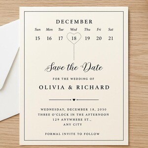 以下が含まれることがあります： 黒い文字が入ったアイボリー色の結婚式の招待状。「Save the Date」はオリビア＆リチャードの結婚式用で、日付は2050年12月18日です。白い封筒が木製の表面の招待状の隣にあります。