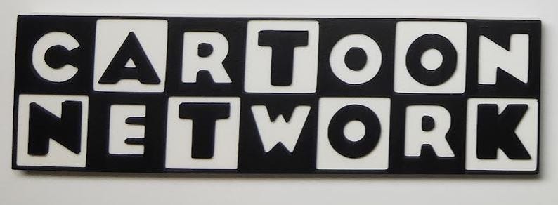 May include: A rectangular sign with the words "CARTOON NETWORK" in bold, black letters. The letters are set against a white background within black squares, creating a high-contrast design. The sign is likely a decorative item.