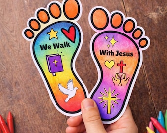 Può includere: Un paio di ritagli colorati a forma di piede con le scritte "We Walk" e "With Jesus". I ritagli presentano simboli religiosi come una croce, una colomba e un cuore, con la frase "this item was prayed over" sopra.