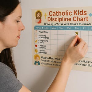 Puede incluir: Un gráfico de disciplina para niños católicos beige con ilustraciones y texto. El gráfico incluye secciones para rastrear virtudes como el tiempo de oración y la bondad. Una persona está colocando una pegatina de estrella dorada en el gráfico.