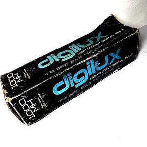 May include: A black box with the word "digilux" in blue and white lettering. The box also has the text "HIGH OUTPUT DIGITAL BULB" and "THE BEST BULB FOR DIGITAL BALLASTS". The box is slightly worn.