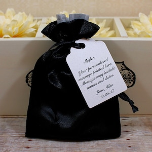 May include: Black satin bag with a white tag that says "Skyler, Your personalized message printed here. Message may include names and dates. Love, Kim 12.25.17"