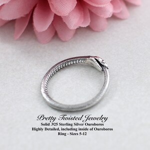 Puede incluir: Un anillo de plata con forma de serpiente mordi&eacute;ndose la cola, conocido como ouroboros. El anillo es muy detallado, incluyendo el interior del ouroboros. El anillo est&aacute; hecho de plata de ley 925 y est&aacute; disponible en tallas 5-12.
