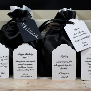 May include: Five white gift tags with black text. The tags have different messages, including "Happy Birthday Skyler!" and "Thank you for always being there for me. I love you, David."
