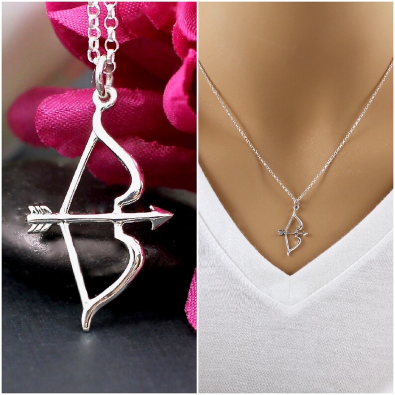 May include: A silver necklace with a bow and arrow pendant. The pendant is a simple design with a heart-shaped bow and a straight arrow.