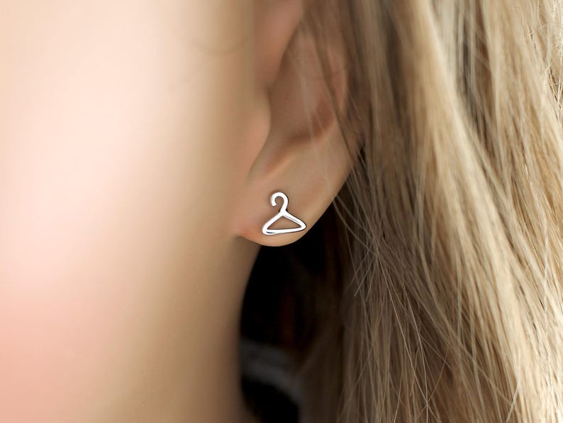 May include: A pair of silver earrings shaped like a hanger.