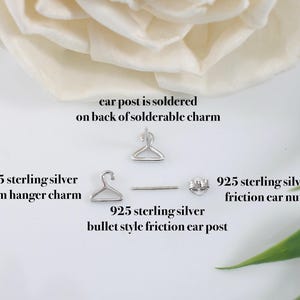 May include: A close-up of a 925 sterling silver hanger charm earring. The earring features a 7mm hanger charm, a bullet style friction ear post, and a friction ear nut. The ear post is soldered to the back of the charm.