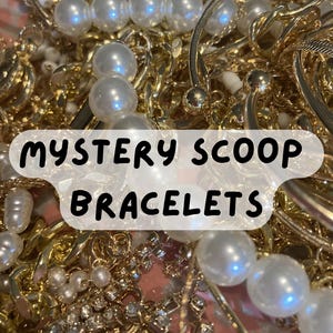 May include: A collection of gold-toned bracelets, chains, and bangles, some adorned with faux pearls and crystals. The image features the text "MYSTERY SCOOP BRACELETS" in a white, rounded font, suggesting a surprise assortment of jewelry.